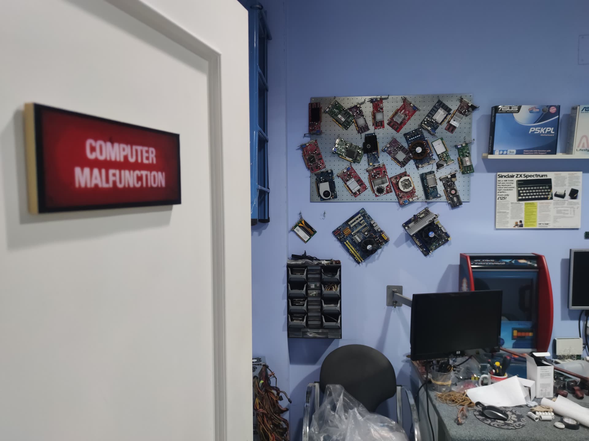 Taller de PlanetaPC Informática en Sevilla, con placas base y componentes en la pared